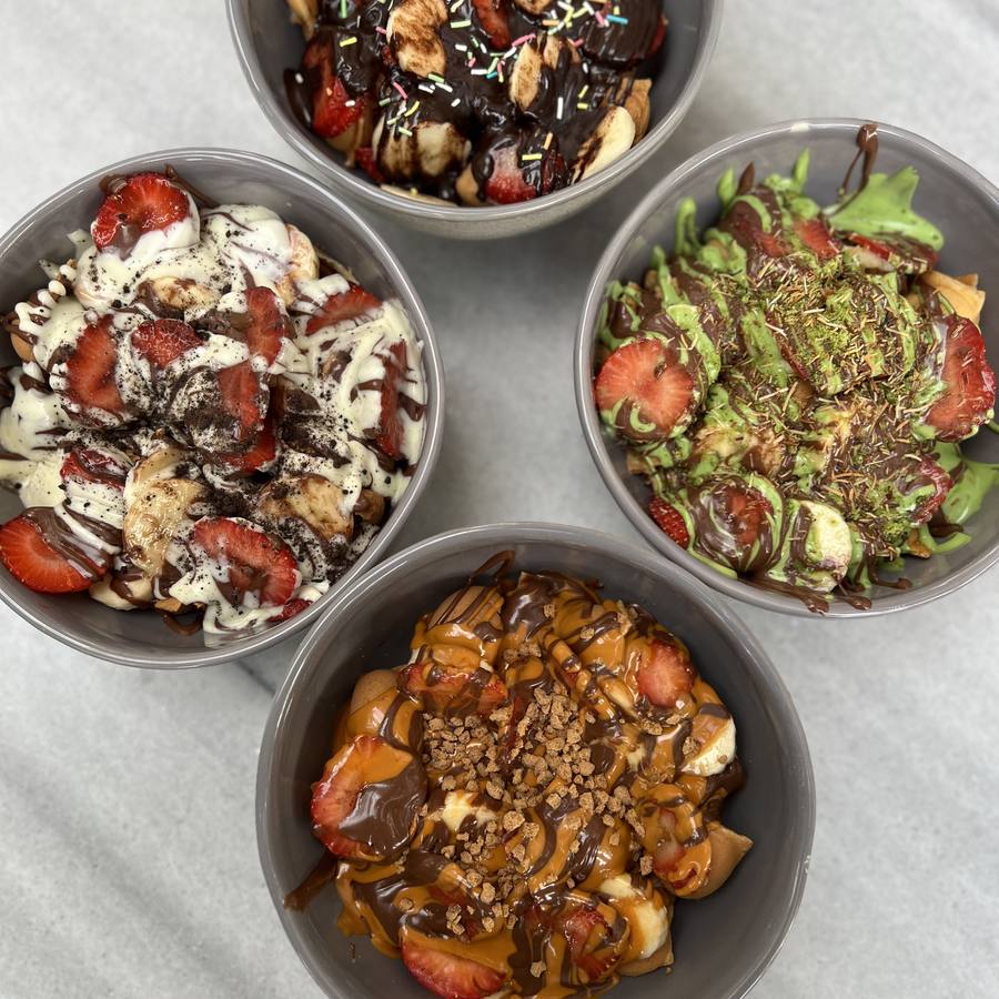 Dört çeşit soslu bubble waffle kasesi — çilek, muz, çikolata, Antep fıstığı ve lotus